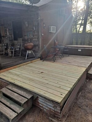 A wooden deck with a grill and outdoor furniture.