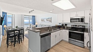 A modern kitchen with white cabinets, stainless steel appliances, and a central island.