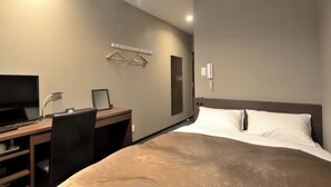 A hotel room with a bed, desk, chair, television, and a wall-mounted towel rack. - Daiwa Link Hotel Minamisoma (Minamisoma)