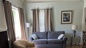 A living room with a sofa, armchair, and a fireplace. - Relax, unwind and enjoy!  (Cody)