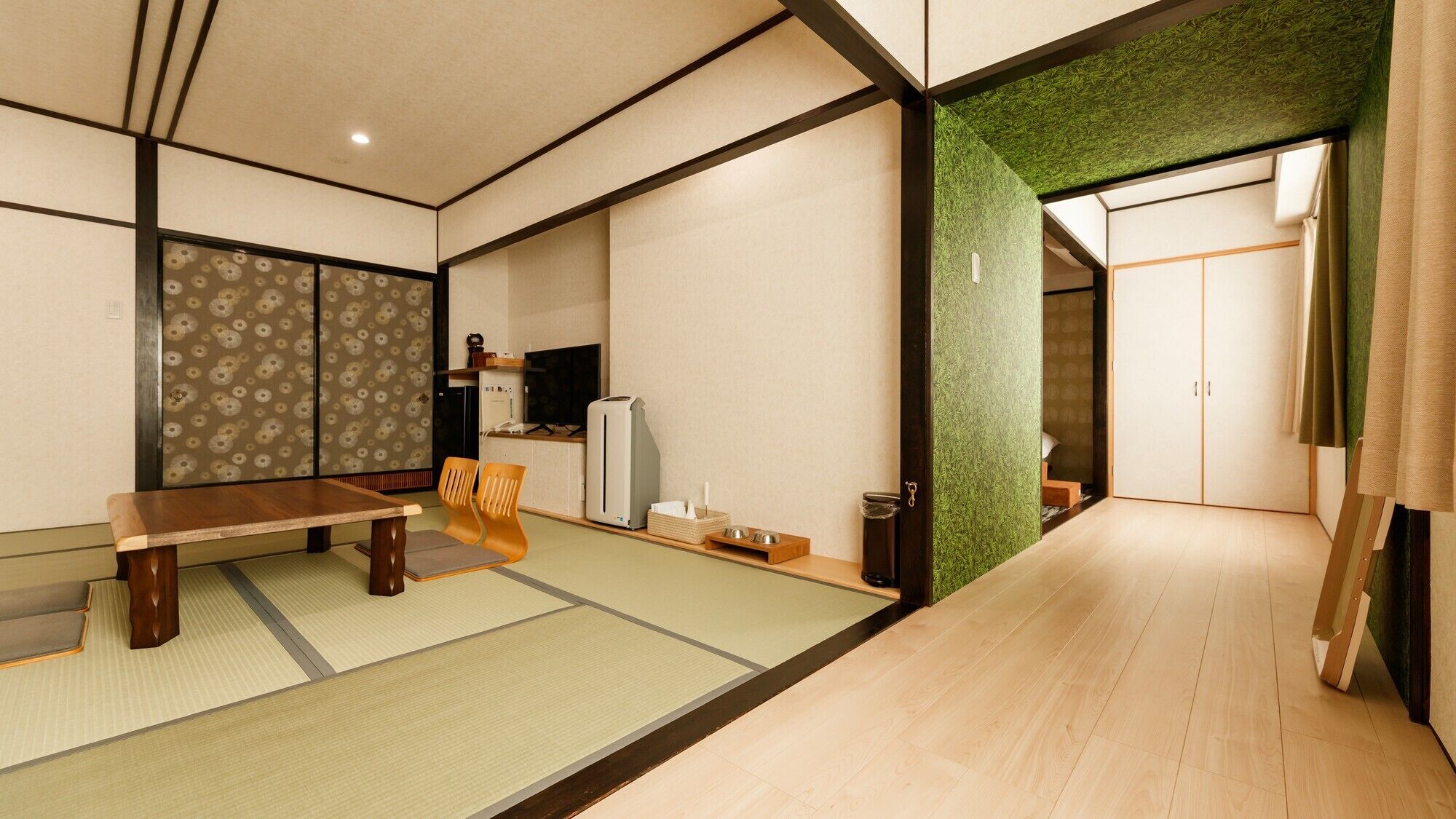 A traditional Japanese-style room with tatami flooring, a low table, and a sliding door.