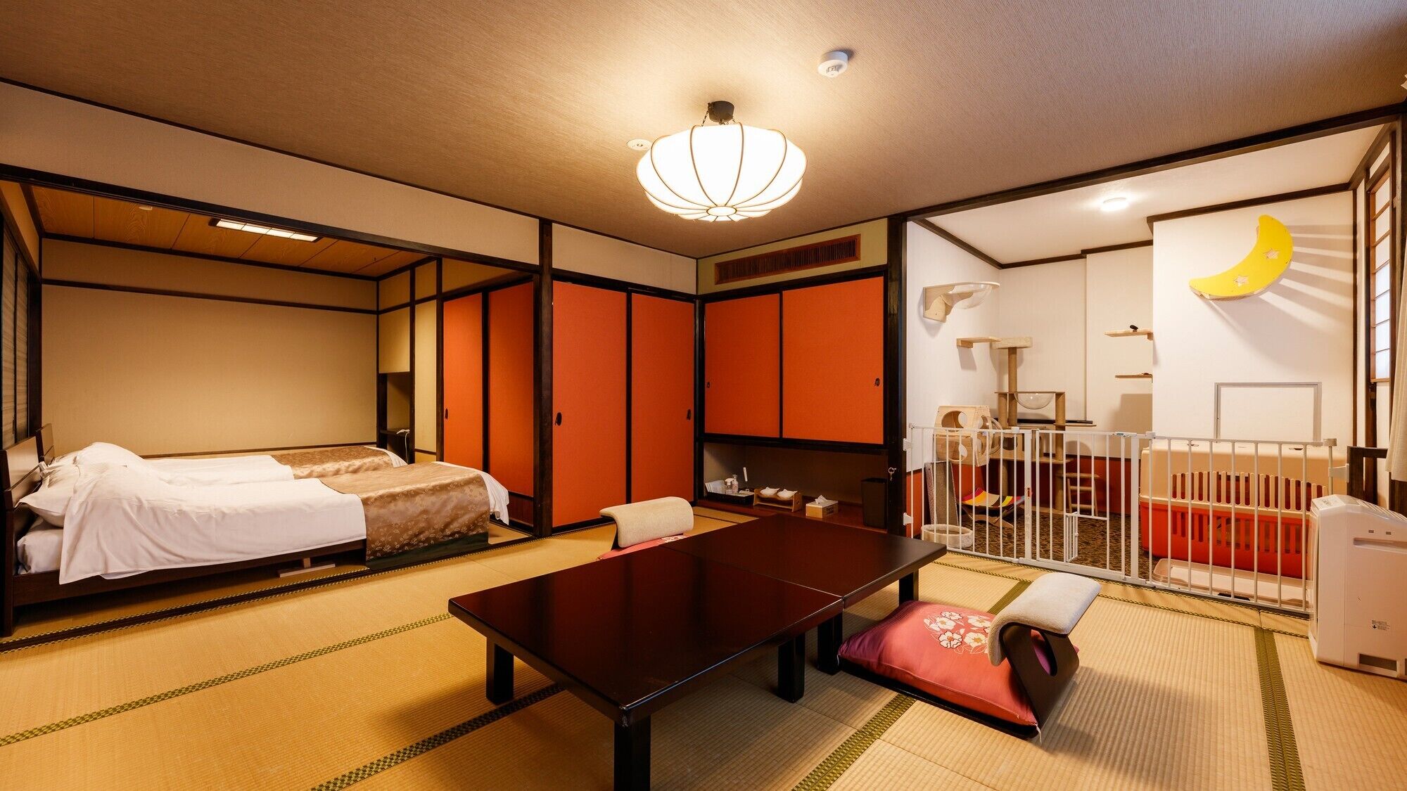A traditional Japanese-style room with tatami flooring, a low table, two beds, and sliding doors.