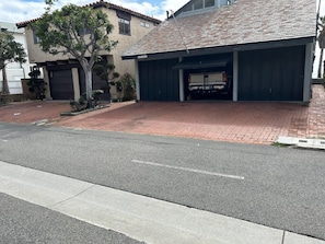 A residential garage with a truck parked inside, a tree in front, and a paved driveway. - Whale Rock House Beach Front (2nd FL) - (STR#03-2662) (Dana Point)