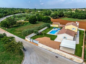 Une propriété résidentielle dotée d’une piscine, d’un garage et d’une pelouse bien entretenue.