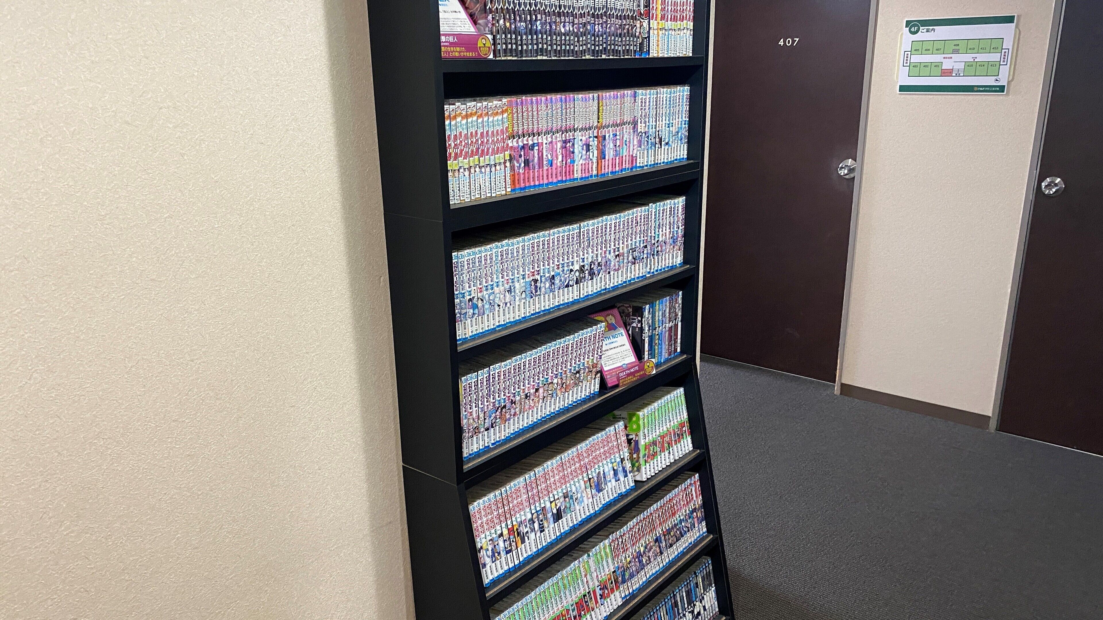 A bookshelf filled with colorful books in a hallway.