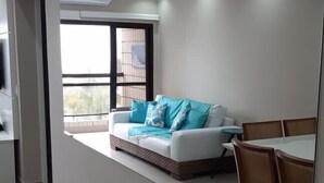 Un dormitorio moderno con una cama grande, una mesa de comedor y vistas al exterior a través de una ventana.