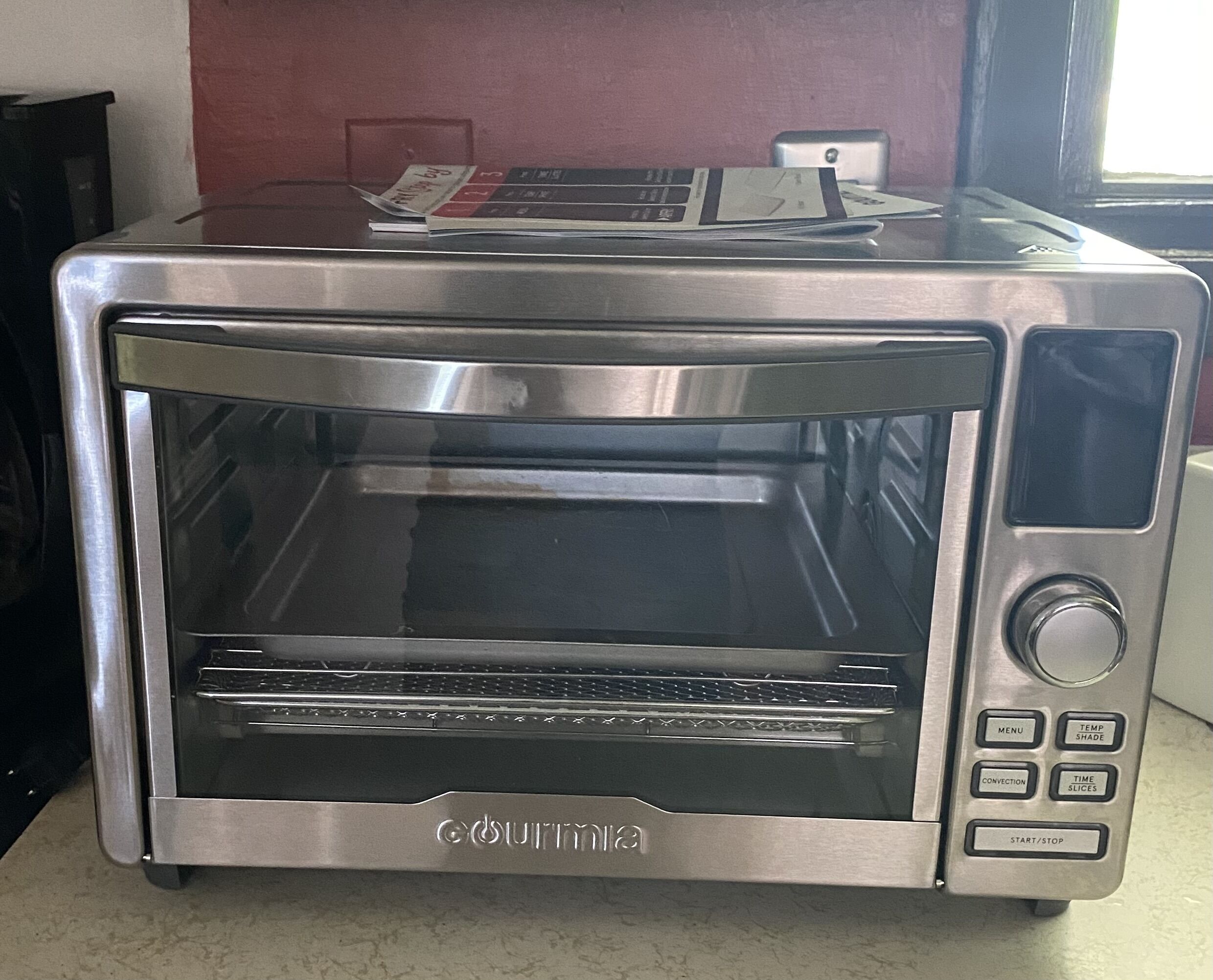 Horno tostador de acero inoxidable con pantalla digital y panel de control.