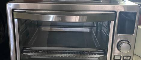 Horno tostador de acero inoxidable con pantalla digital y panel de control.