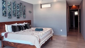 Een slaapkamer met een houten bed, een plafondventilator en een wandlamp.
