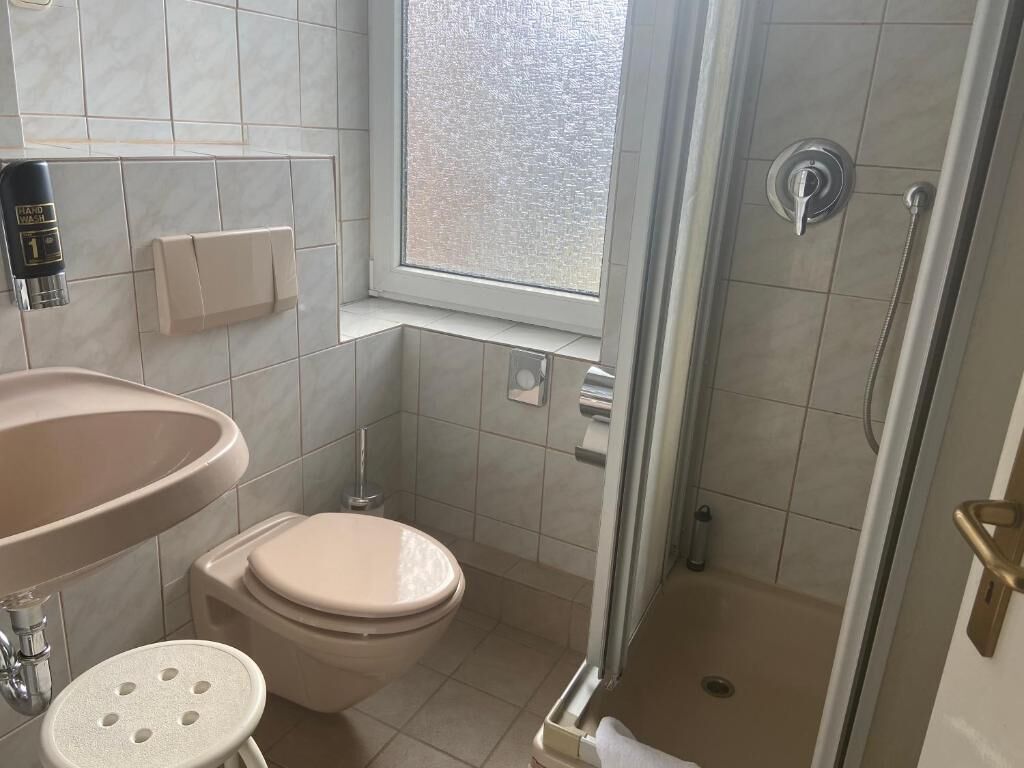 Ein kleines Badezimmer mit Toilette, Waschbecken und Dusche.