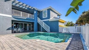 A two-story house with a swimming pool, a covered patio, and a white fence. - "Seas the Day" (Week or Month) on Ormond Beach with  Pool and Ocean Views (Ormond Beach)