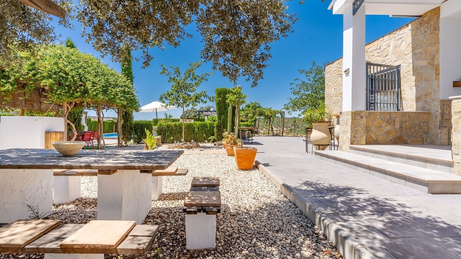 An outdoor patio area with stone steps, a pool, and potted plants.
