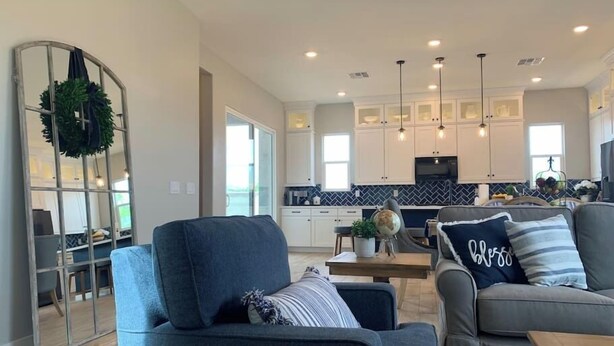 A modern living room with a sofa, a coffee table, and a decorative mirror.