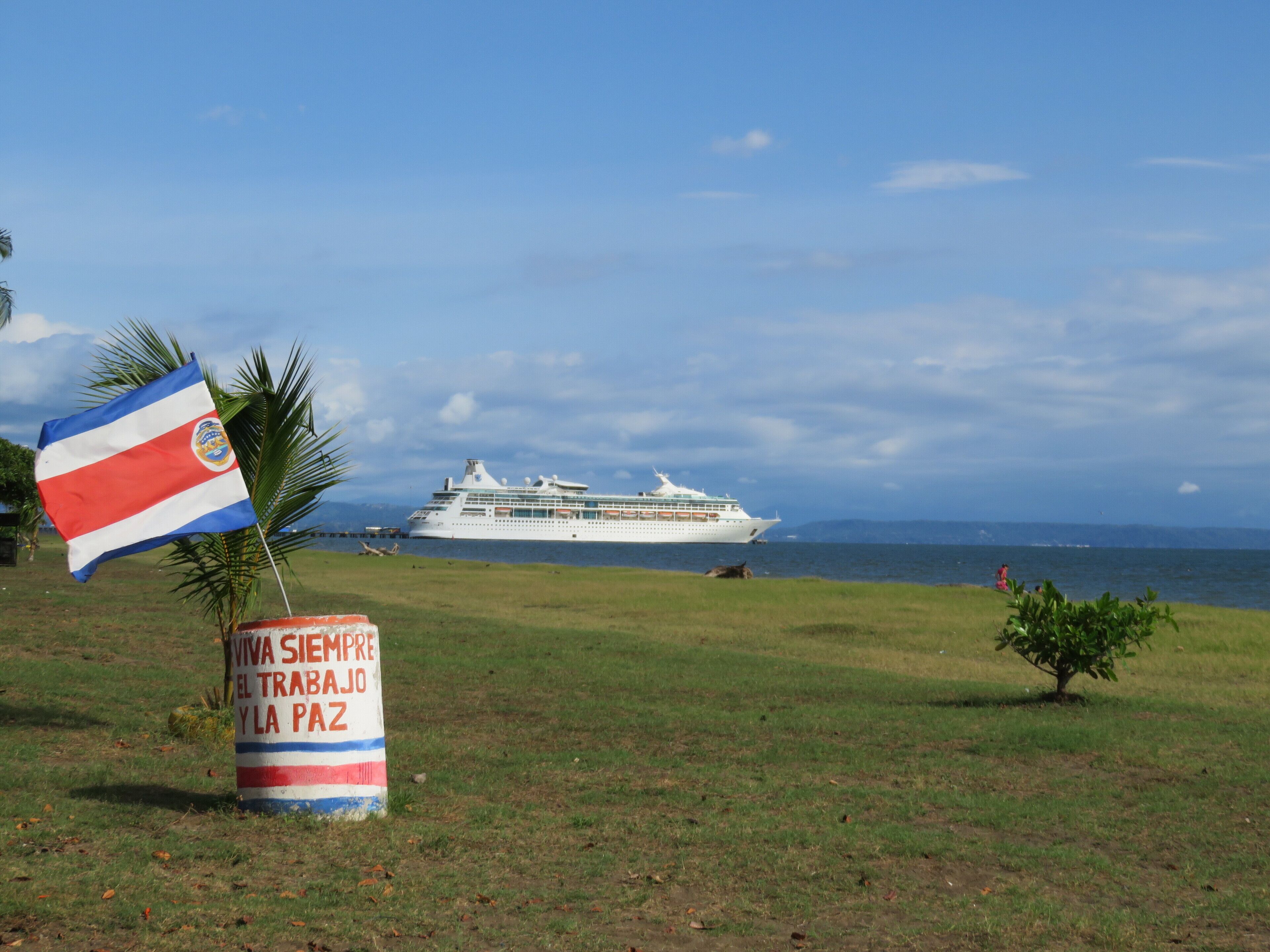 Un crucero amarrado en un puerto con una bandera y un cartel al frente.