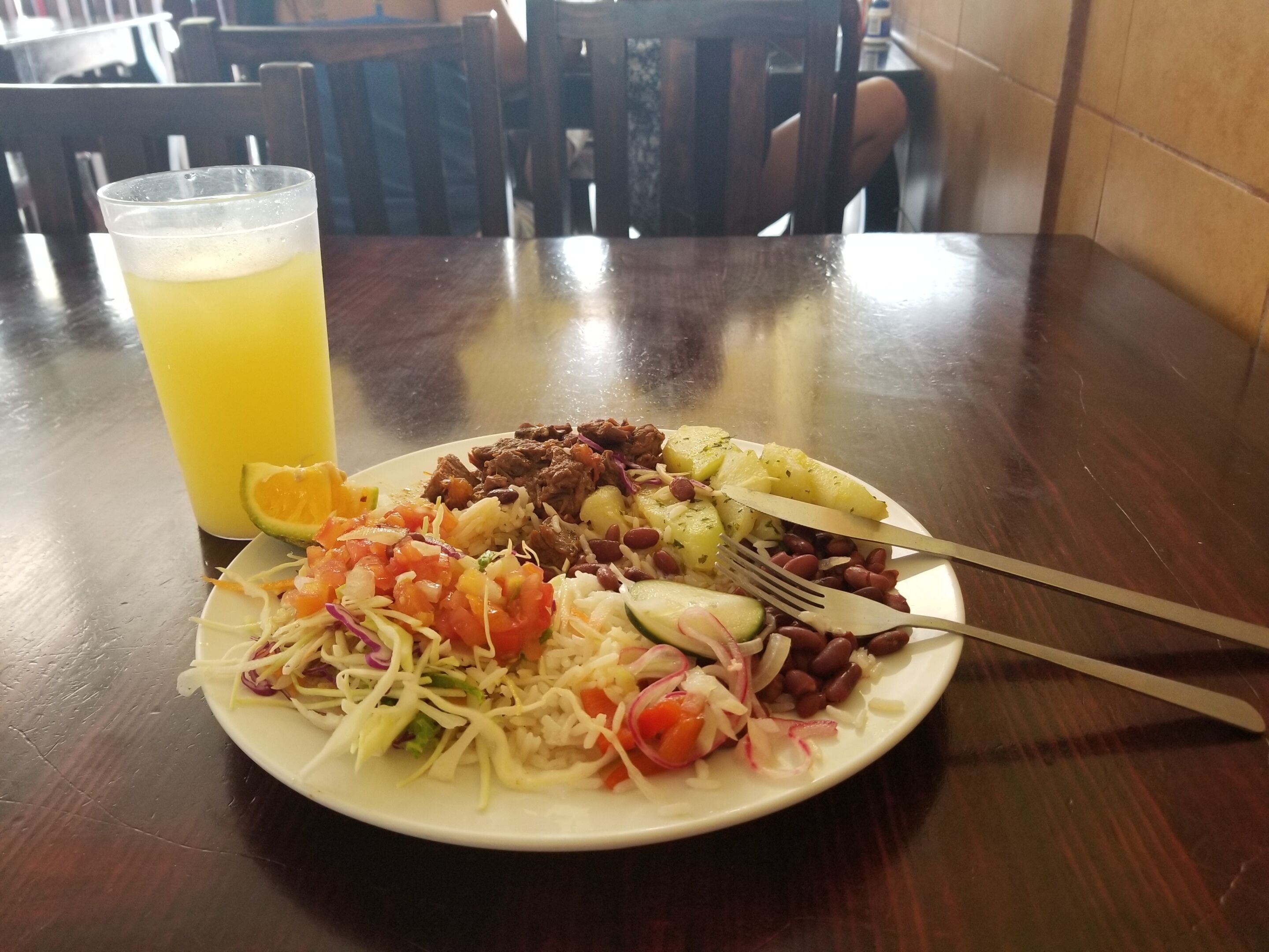 Ein Teller Essen mit einem Getränk auf einem Holztisch in einem Restaurant.