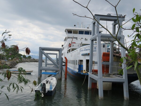 Un ferry atracado en el muelle, con un bote pequeño al frente.