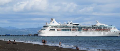 Un grand navire de croisière était amarré à un quai, avec une plage en arrière-plan.