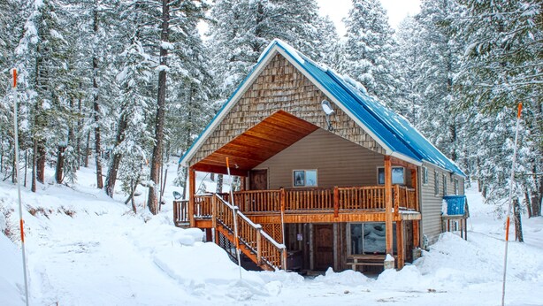 Eine Holzhütte mit Balkon und überdachter Veranda.