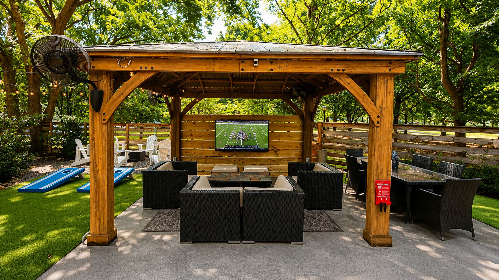 An outdoor patio area with a wooden pergola, seating, a flat-screen TV, and a fire blanket sign.