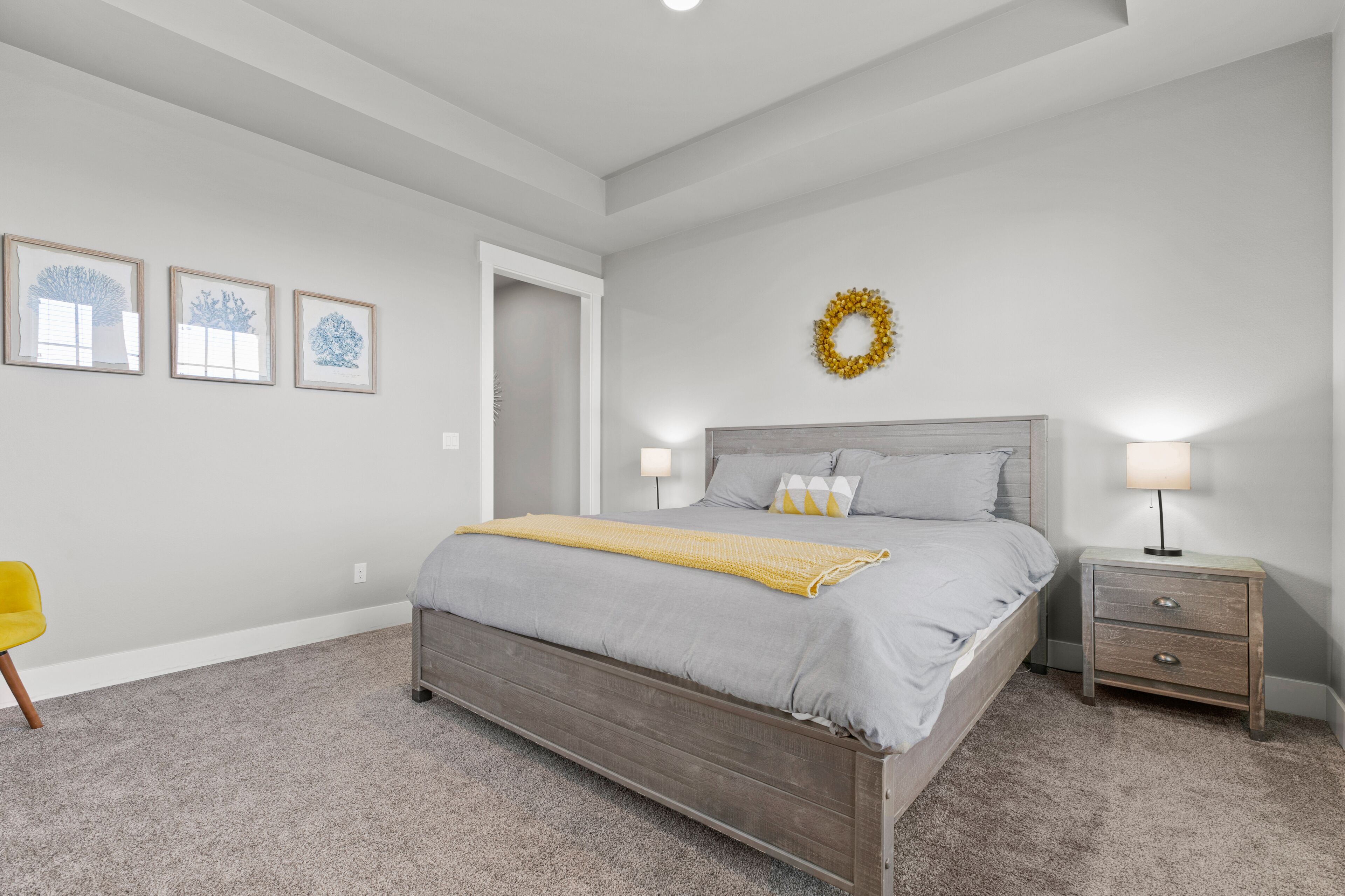 A bedroom with a bed, bedside table, and a chair.