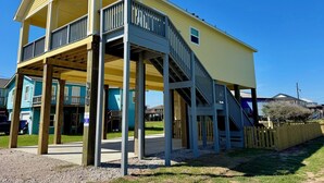 A two-story building with a balcony and a staircase. - The Sea Glass Retreat - Surfside Beach Texas (Freeport)