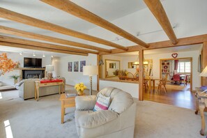 Relax in this inviting living room with a comfortable sofa, dining area, and fireplace.