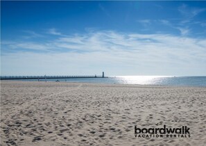 Enjoy a serene beach experience with a long pier and lighthouse.