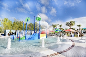 Parque acuático con una fuente central, toboganes y un área de piscina.