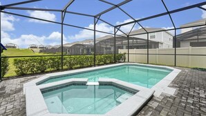 A swimming pool with a glass enclosure, surrounded by a brick patio and a view of residential houses. - Windsor Island Pool Home | Rare Backyard Privacy | 3 Master Suites | Game Room (Davenport)