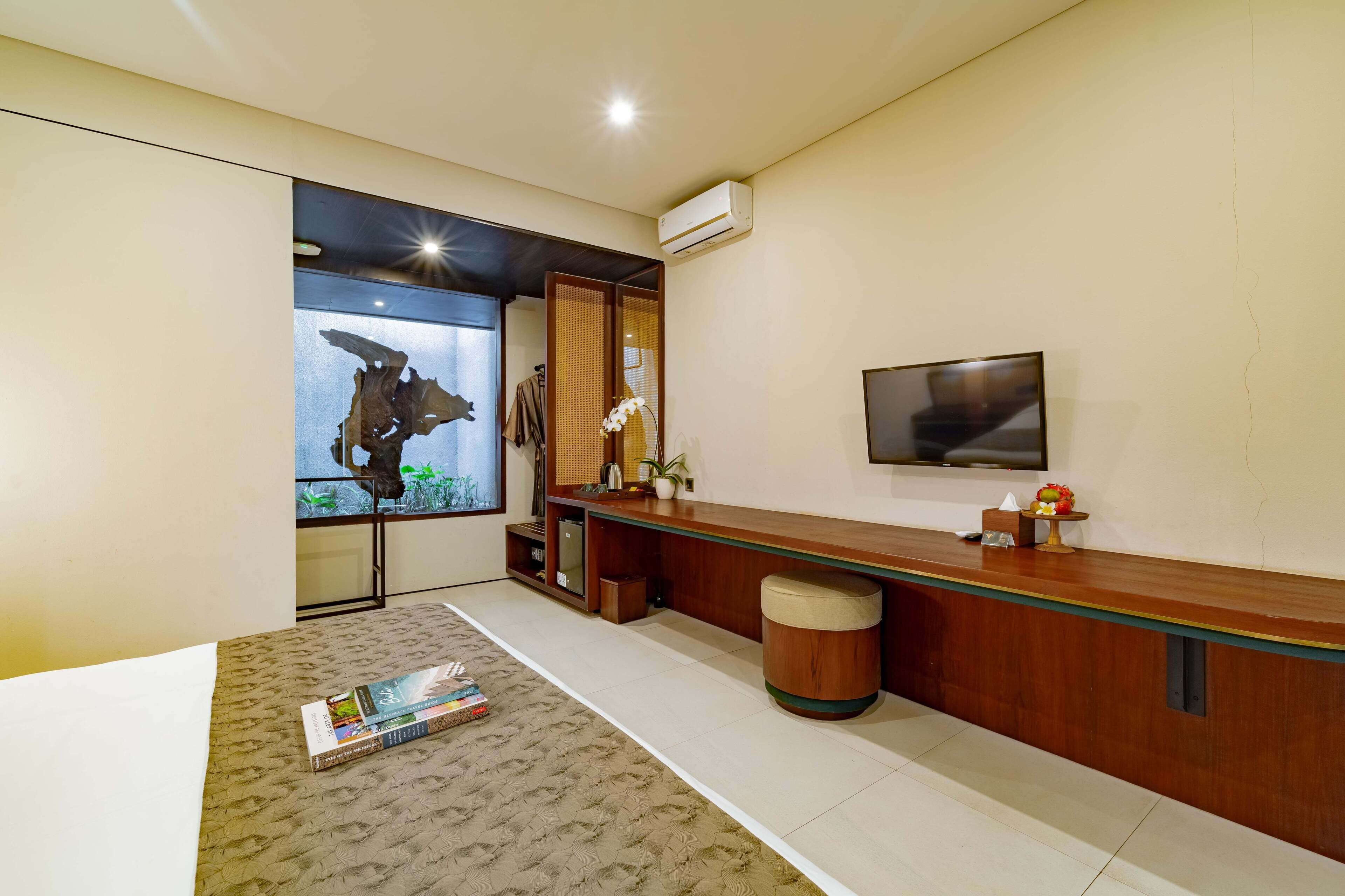 Un soggiorno moderno con una reception in legno, una TV a schermo piatto montata a parete e un'ampia finestra vista all'esterno.