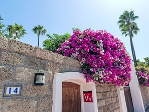 A stone building with a wooden door and a sign with the letter 'W'.
