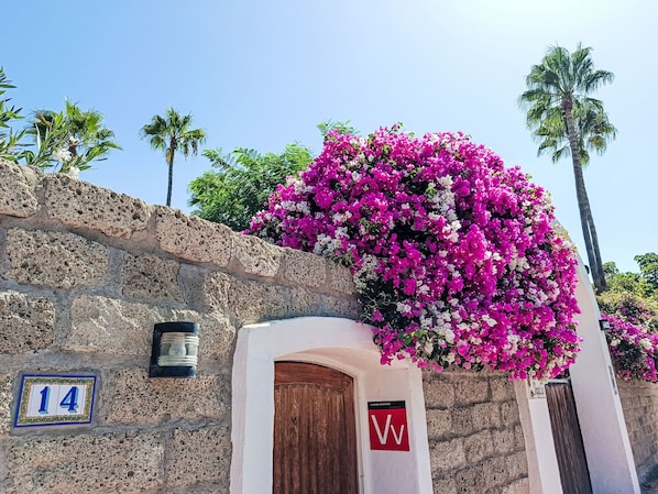 A stone building with a wooden door and a sign with the letter 'W'.