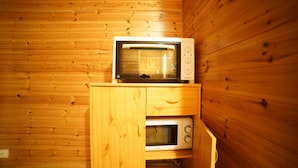 Ein Holzinrichtungsraum mit einer Mikrowelle auf einem Holzschrank.