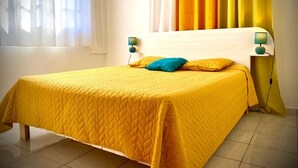 A room with a bed covered in yellow bedding, a window with curtains, and a wall-mounted air conditioner. - ★ Sopraia Nature ★ New ✯ Countryside ✯ Calm (Les Abymes)