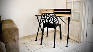 A small, well-lit room with a wooden desk and a black chair with a geometric backrest. A beige bench is visible to the left. - ★ Sopraia Nature ★ New ✯ Countryside ✯ Calm (Les Abymes)