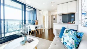 Una sala de estar moderna con sofá, mesa de comedor y área de cocina.