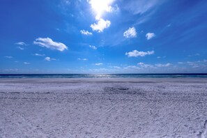 Une plage avec un ciel dégagé et une mer calme.