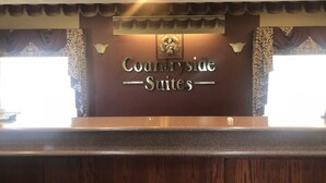 Balcão de recepção com placa indicando "Countryside - Suites".