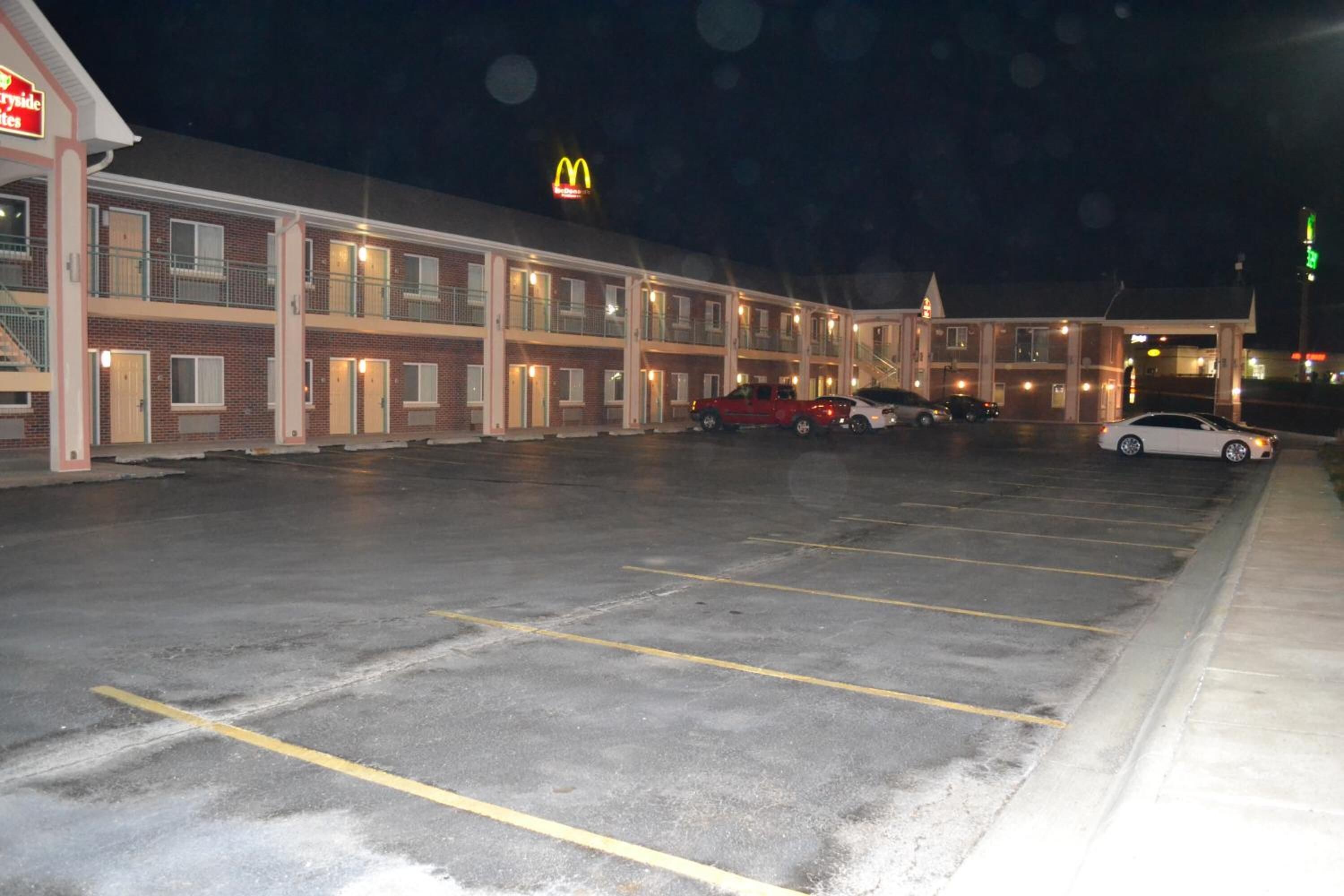 Um motel com várias divisas, um letreiro do McDonald's e um estacionamento com vários carros.