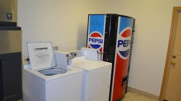 Un área de lavandería con lavadora y refrigerador con la marca Pepsi.