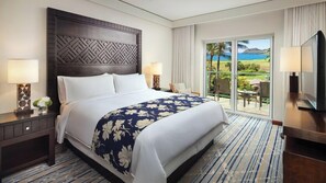 Habitación de hotel con una cama grande, vistas al exterior y un televisor a la derecha.