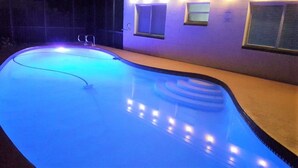 A swimming pool with a curved edge and a blue light.