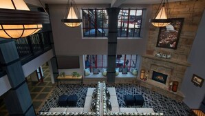 A spacious indoor area with a fireplace, seating, and large windows.