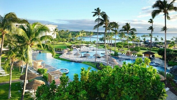 A resort with a large pool, palm trees, and a view of the ocean. - Marriotts Waikoloa Ocean Club - 2 Bedroom (Big Island)