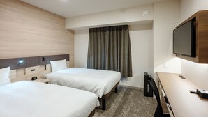 A hotel room with two beds, a desk, a television, and a window with curtains. - Smile Hotel Okayama (Okayama)