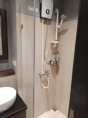 A shower with a handheld showerhead, a wall-mounted faucet, and a handheld showerhead. - Studio Unit at The Beacon Makati (Makati)
