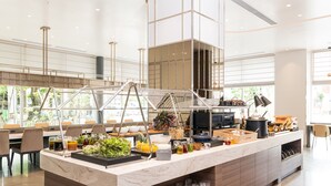 Een moderne keuken met een marmeren aanrecht, roestvrijstalen apparatuur en diverse etenswaren en drankjes.
