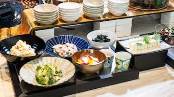 A buffet table with various dishes and bowls.