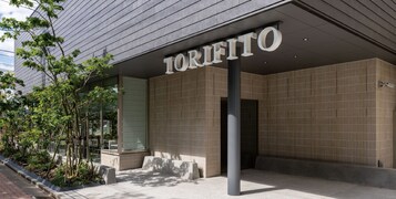 Fachada de edificio moderno con el nombre "TORIFITO" bien visible.