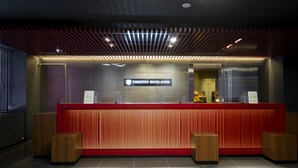 A reception desk with a modern design, featuring a red and black color scheme, and a sign that reads "TORIFITO HOTEL & POD". - TORIFITO HOTEL&POD KANAZAWA Hyakumangoku-Dori (Kanazawa)